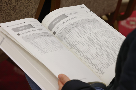 지난해 12월 12일 서울 광진구 세종대학교 광개토관에서 열린 서울특별시교육청 교육연구정보원 주최 2023 대입 정시모집 설명회 참석자가 책자를 살피고 있다. [연합뉴스]